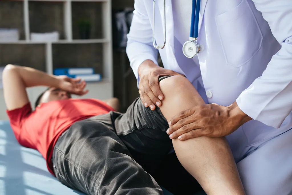 A medical professional assessing a patient’s knee injury