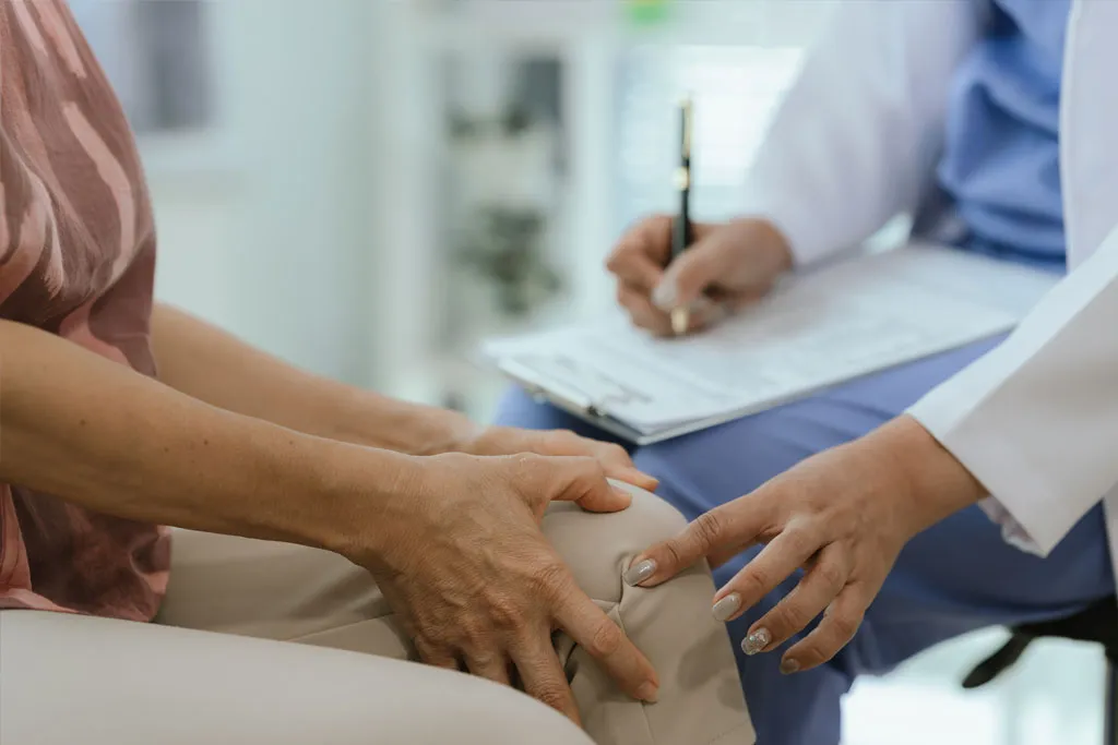 A doctor assessing a patient’s knee arthritis in a clinical setting