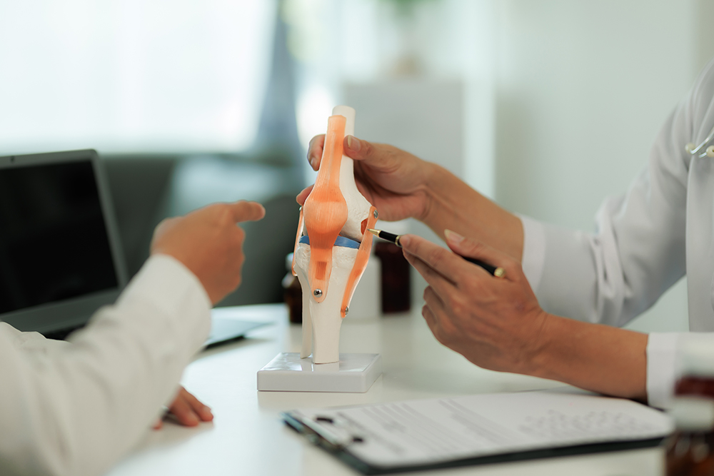 Close-up of a specialist discussing knee arthritis treatment with a patient