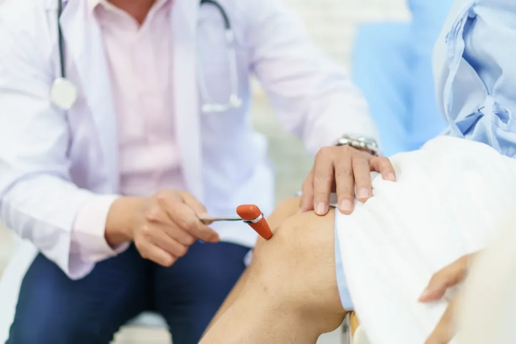 Orthopedic doctor examines elderly woman's knee.